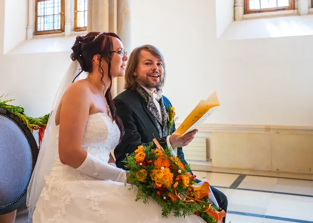 Braut und Bräutigam bei der Trauung mit Blumenstrauß