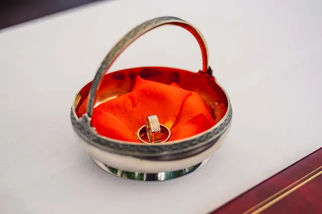 Silberne Ringschale mit Ehering auf rotem Samt